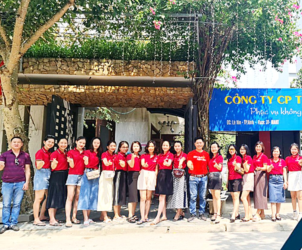 Tập thể nhân viên Tâm - Tầm - Tài trước biển hiệu công ty tại TP. Vinh